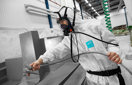 Man performing spray painting in breathing air equipment connected with CEJN hose and quick couplings